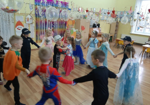 Chłopczyk z dziewczynką tańczą walca, pozostałe dzieci tańczą w kole dookoła nich.